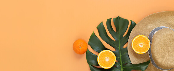 Flat lay with monstera leaf, summer women's hat and oranges. Summer concept, copyspace. Summer vacation fashion, holiday concept. Beach accessories on a light background with space for text