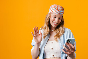 Poster - Young blonde woman waving hand and using cellphone