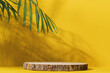 Wooden cut podium on yellow background with palm tree shadow. Stand for the presentation of beauty products, cosmetics