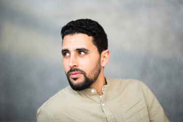 Wall Mural - Young arabic man looking away against grey background