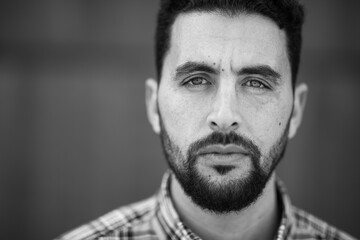 Wall Mural - Close up of serious young arabic man staring at camera