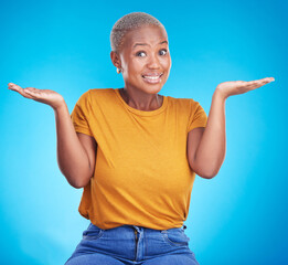 Wall Mural - Black woman, shrug and confused portrait in studio with hand gesture, emoji or sign for doubt. African female model on a blue background for choice, decision or questions and why or unsure reaction