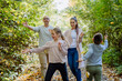 © Halfpoint - Happy family having fun with a foliage in autumn forest.
