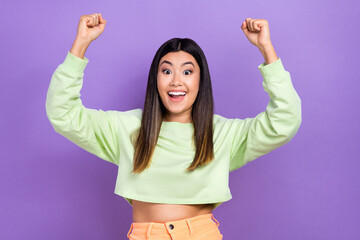 Sticker - Portrait of optimistic impressed ecstatic girl wear stylish pullover raising hands up at amazing sale isolated on violet color background