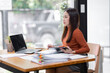 © David - Attractive smiling young asian business woman wear glasses work at home office, Asian woman working on laptop computer holding tablet.business finance concept.
