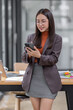 © David - Portrait of a happy Asian businesswoman using mobile phone indoor, Asian businesswoman working in modern office.