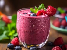 Homemade Raspberry And Blueberry Smoothie With Mint In Glasses And Berries On Wooden Table, Close-up