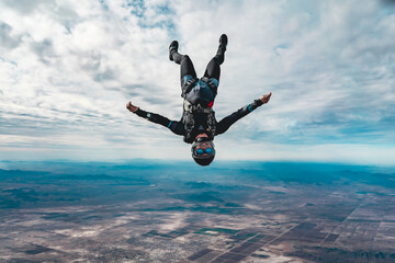 Woman skydiver in freefall alone over desert landscape