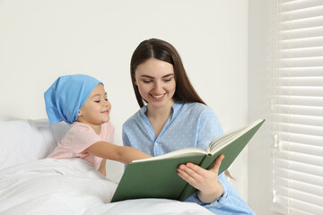 Canvas Print - Childhood cancer. Mother and daughter reading book in hospital