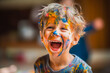 © MVProductions - Candid image of a young smiling boy, engaged in painting with paint on his face and hands. Young creative hands, generative ai