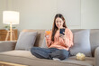 © Kris Tan - Happiness young woman using mobile phone for relaxing time at home.