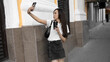 © Petr - Beautiful young woman with mobile phone drinking coffee on the city street.