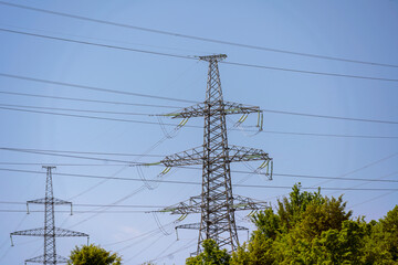 High voltage towers with sky background. Power line support with wires for electricity transmission. High voltage grid tower with wire cable at distribution station. Energy industry, energy saving