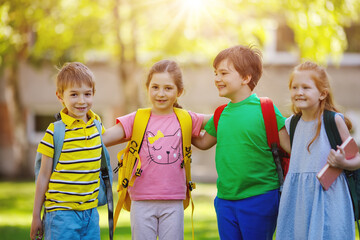 Wall Mural - Group of children standing with backpacks near the school.