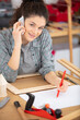 © auremar - r female carpenter talking on the phone in her workshop