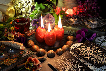 Wall Mural - Still life with tarot cards, red candles, magic wand and book of spells on ritual table. Occult, esoteric and witchcraft concept. Mystic background with vintage objects