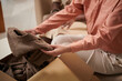 © DragonImages - Closeup image of woman taking brown jacket out box to wear during new season