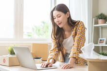 Online Sell Store, Startup Small Business Entrepreneur Asian Young Woman Using Laptop Computer Check Order Purchase From Web, Owner Working At Home Office, Preparing Pack Product Parcel For Delivery.