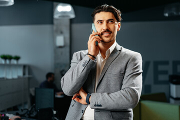 Poster - Young arab businessman working at modern office, talking on mobile phone