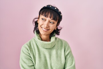 Canvas Print - Young beautiful woman standing over pink background looking away to side with smile on face, natural expression. laughing confident.