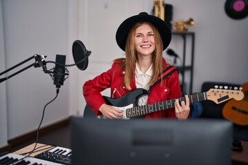 Canvas Print - Young blonde woman musician singing song playing electrical guitar at music studio