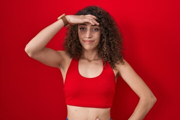 Sticker - Hispanic woman with curly hair standing over red background worried and stressed about a problem with hand on forehead, nervous and anxious for crisis