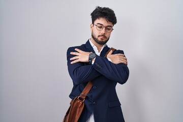 Wall Mural - Hispanic man with beard wearing business clothes hugging oneself happy and positive, smiling confident. self love and self care