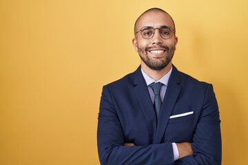 Wall Mural - Hispanic man with beard wearing suit and tie happy face smiling with crossed arms looking at the camera. positive person.