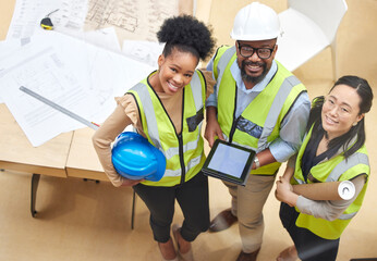 Canvas Print - Tablet, teamwork or portrait of engineers with designer planning a construction for architecture. Top view, blueprint or happy black people with Asian woman meeting together on a development project