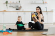 © sofiko14 - Beautiful lady and adorable child sitting with soles of feet together on floor while having fun with stretch band. Attentive baby following joyful mom's instructions during physical exercises at home.