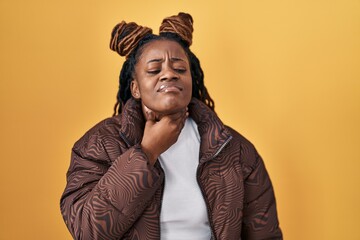 Poster - African woman with braided hair standing over yellow background touching painful neck, sore throat for flu, clod and infection