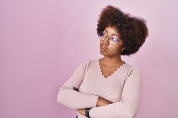 Canvas Print - Young african american woman standing over pink background looking to the side with arms crossed convinced and confident