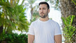 © Krakenimages.com - Young hispanic man standing with serious expression at park