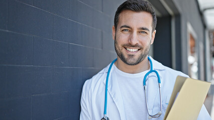 Poster - Young hispanic man doctor smiling confident holding medical report at hospital