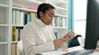 © Krakenimages.com - African american woman student using computer eating waffle at library university