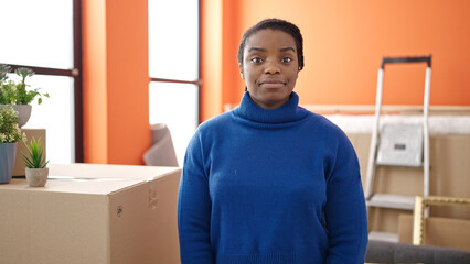 Poster - African american woman standing with relaxed expression at new home