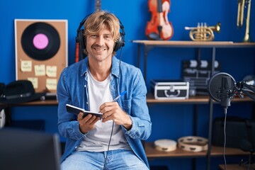 Wall Mural - Young man artist composing song at music studio