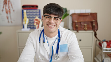 Sticker - Young hispanic man doctor smiling confident wearing stethoscope at clinic