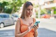 © Krakenimages.com - Young beautiful hispanic woman using smartphone with relaxed expression at street
