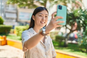 Sticker - Chinese woman smiling confident making selfie by the smartphone at park