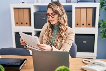 Wall Mural - Young woman business worker reading document working at office