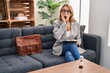 © Krakenimages.com - Hispanic woman working at consultation office afraid and shocked, surprise and amazed expression with hands on face