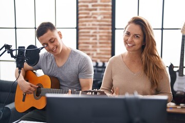 Poster - Man and woman musicians playing classical guitar at music studio