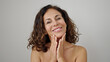 © Krakenimages.com - Middle age hispanic woman smiling confident applying skin treatment over isolated white background