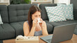 © Krakenimages.com - Young beautiful hispanic woman using laptop sneezing at home