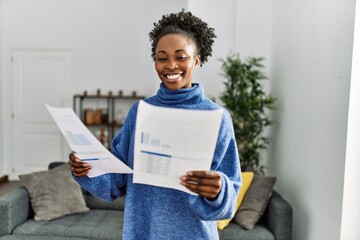 Poster - African american woman reading document standing at home