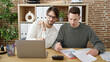 © Krakenimages.com - Two men business partners using laptop writing on document working at office