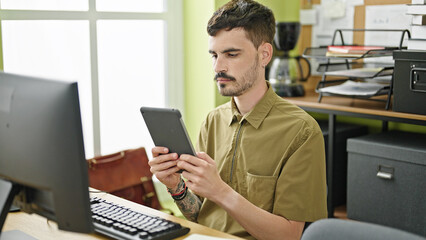 Poster - Young hispanic man business worker using computer and touchpad working at office