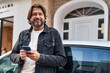 © Krakenimages.com - Middle age man using smartphone leaning on car at street