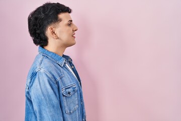 Poster - Non binary person standing over pink background looking to side, relax profile pose with natural face with confident smile.